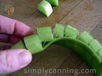 Removing slices of green rhubarb from the stringy or tough part of the stalk.