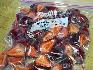 A freezer bag packed with strawberry slices and labeled with the contents and date.