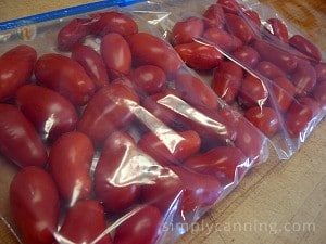 Freezer bags packed with whole unpeeled tomatoes.