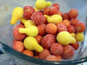 Frosty cherry and pear tomatoes in a glass bowl.