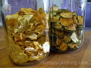 Jars filled with dried yellow and green zucchini chips.