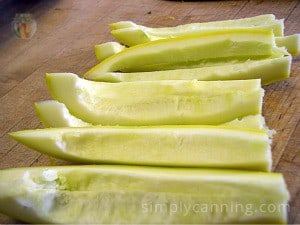 Seeded spears of summer squash sitting on a wooden surface.