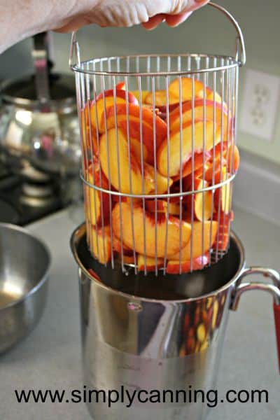 Pulling a basket of sliced peaches out of the 4th burner pot.