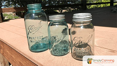 Vintage ball canning jars lined up outdoors.