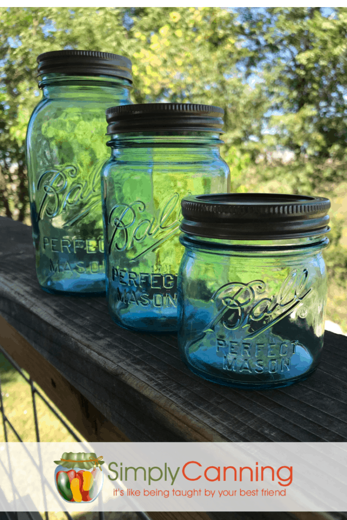 Aqua vintage Ball canning jars lined up outside.