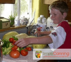 My son washing fresh vegetables in the kitchen.