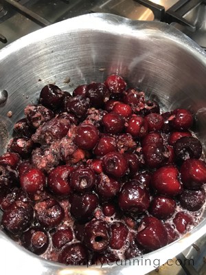 Cherries cooking in a saucepan.