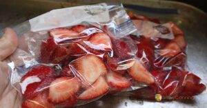Freezer bags filled with sliced red strawberries.