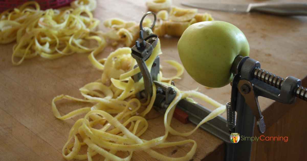 A whole apple being put on the slicer tool.