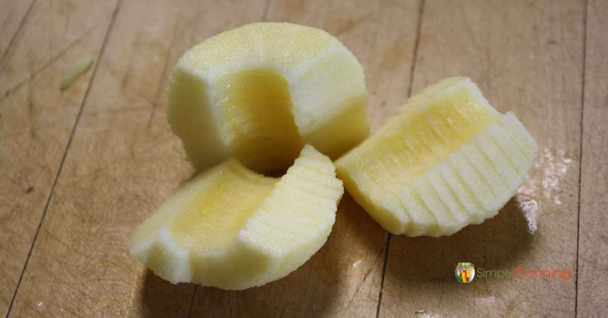 An evenly sliced yellow fleshed apple that’s been peeled.