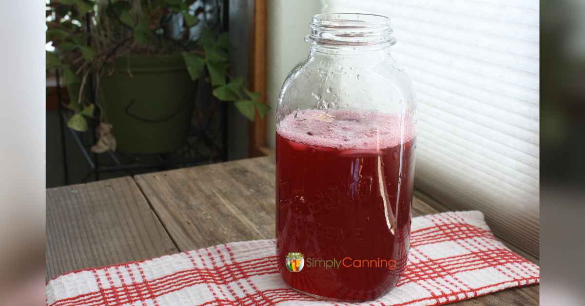 A large jar of red cranberry juice.