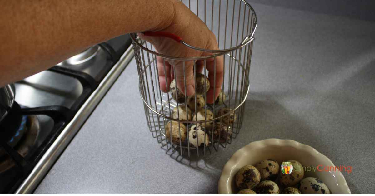 Putting fresh quail eggs into the 4th burner pot basket.