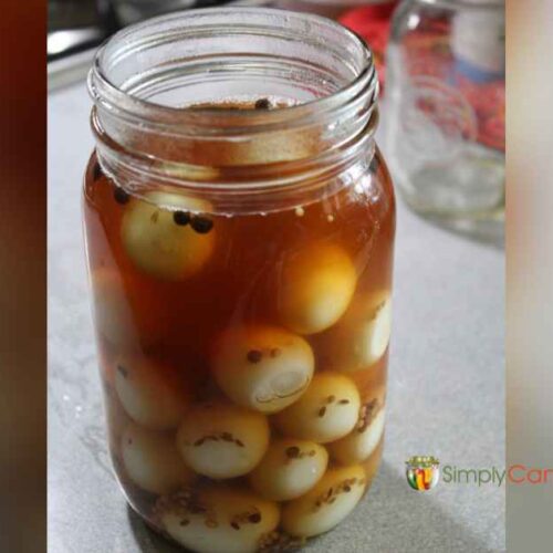 A jar filled with hard boiled quail eggs covered with spicy brine