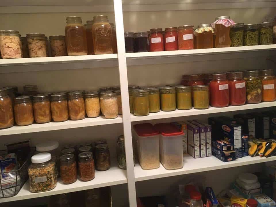 Pantry shelves filled with home canned food and other stored food like dry goods.