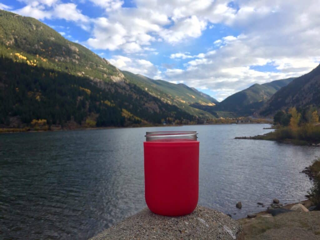 Jar inside of a Mason-re sitting next to a lake.