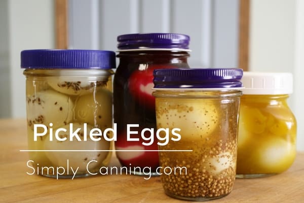 Various jars of beautiful pickled eggs in brine with spices.