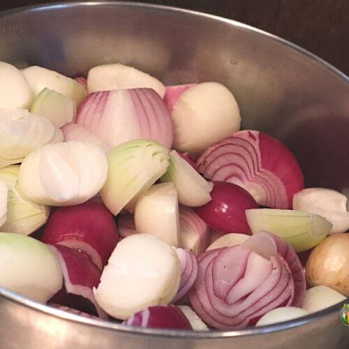 Stainless steel bowl with small white and red onions cut in halves