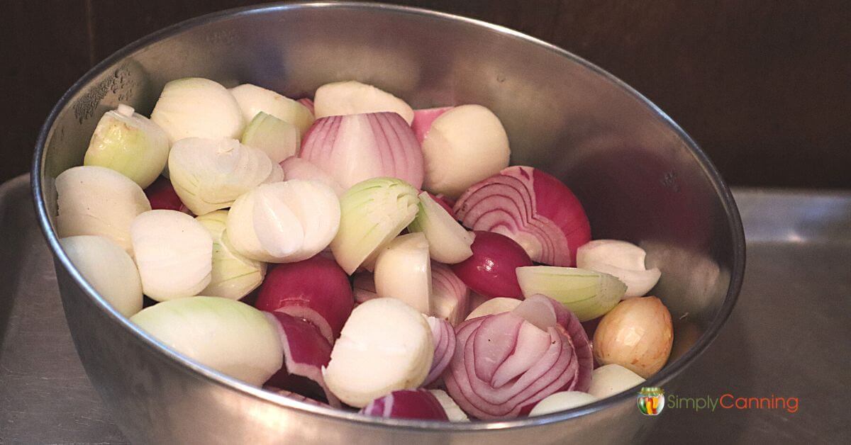 Stainless steel bowl with small white and red onions cut in halves