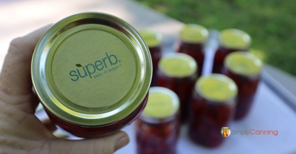 Close up of a Superb Seal it Right canning lid with jars of home canned beets in the background.