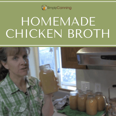 Sharon holding a quart jar of home canned chicken broth with other jars of broth beside her.