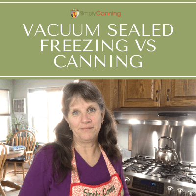 Sharon wearing a Simply Canning apron and standing next to her stovetop with the kitchen table in the background.