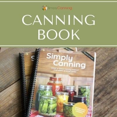 Simply Canning spiral bound cookbook sitting on a wooden surface.