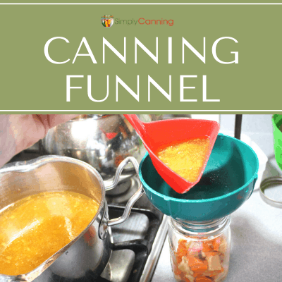 Pouring soup through a green canning funnel that is on top of a canning jar.