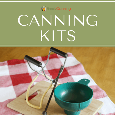 Canning funnel and jar lifter and lid lifter sitting on a wooden cutting board.