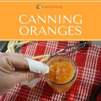 Wiping the rim of a jar that's filled with orange segments.