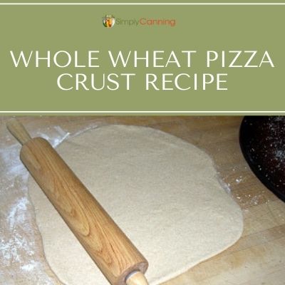 Rolling whole wheat pizza dough out using a long rolling pin.