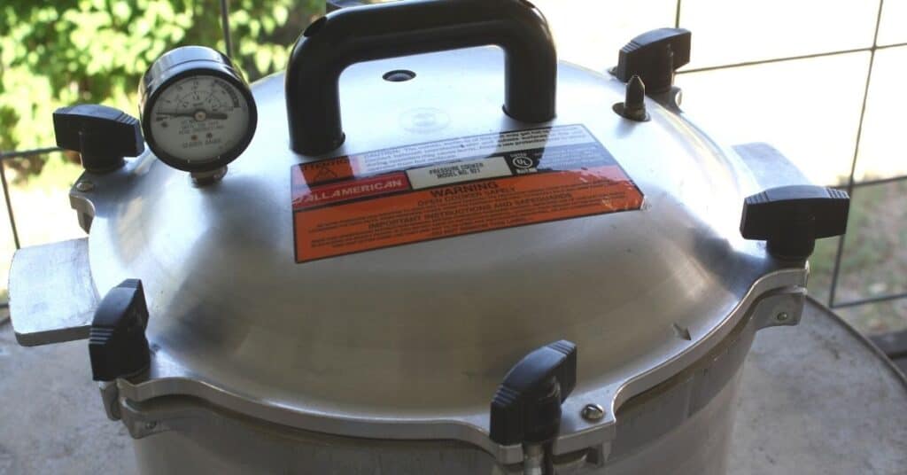 All American canner with the lid clamped down on top of it.