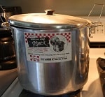 Aluminum water bath canner with label on the side.