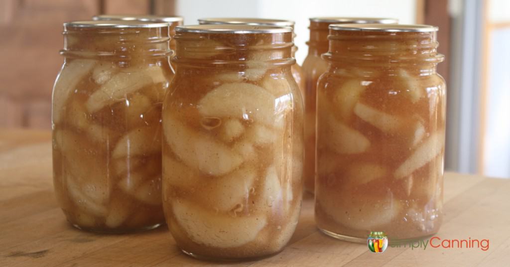 Jars filled with thick apple pie filling.