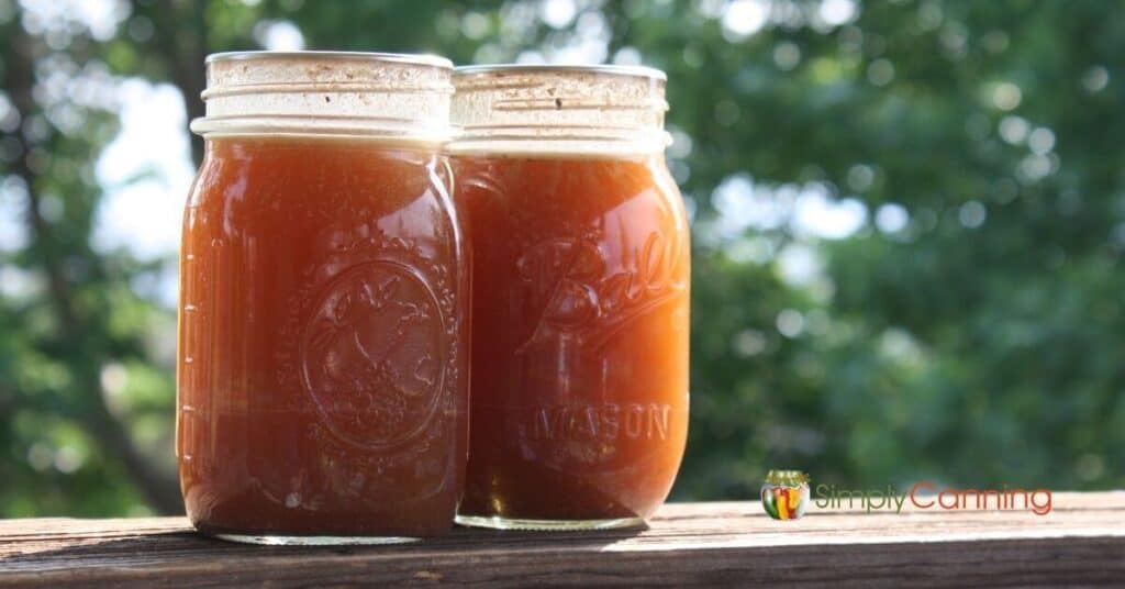 Two jars of canned homemade beef broth.