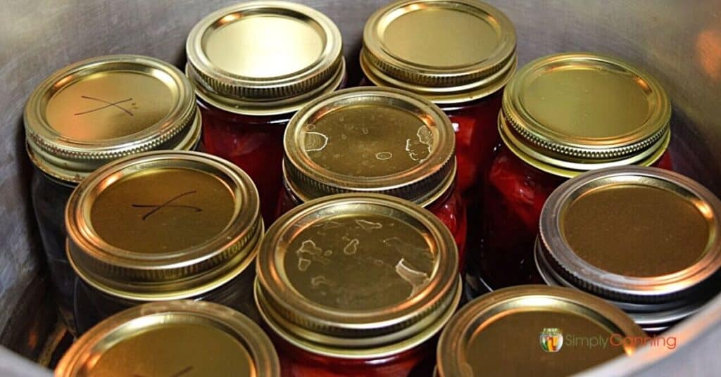 close up of the lids of canning jars in a pressure canner.