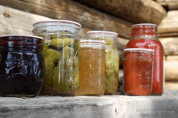 More jars of home canned food including jam and pickles.