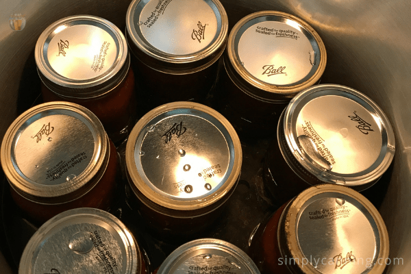 Looking down at the tops of the jars in a canner.