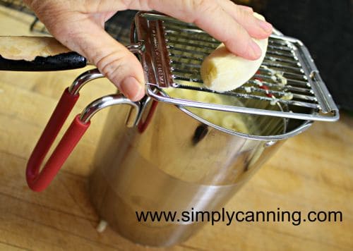 Slicing a banana into the lemon juice mixture in the 4th burner pot.