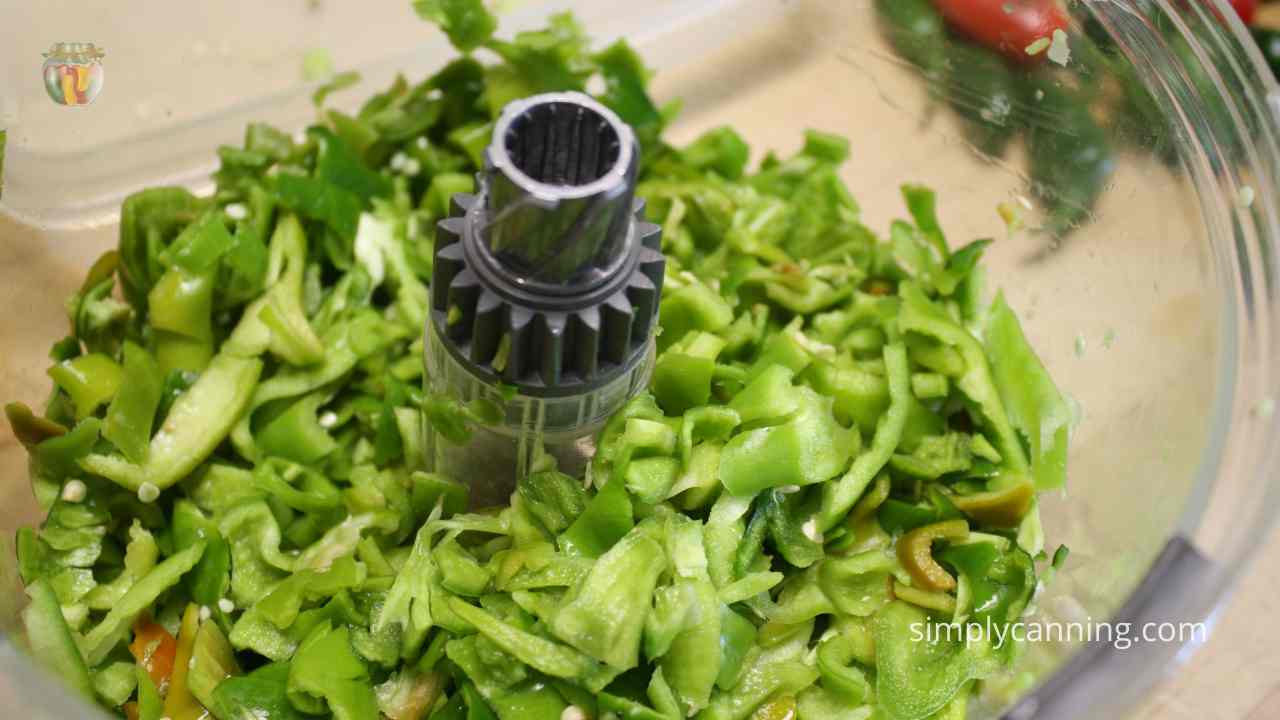 Close up of chopped peppers in a food processor.