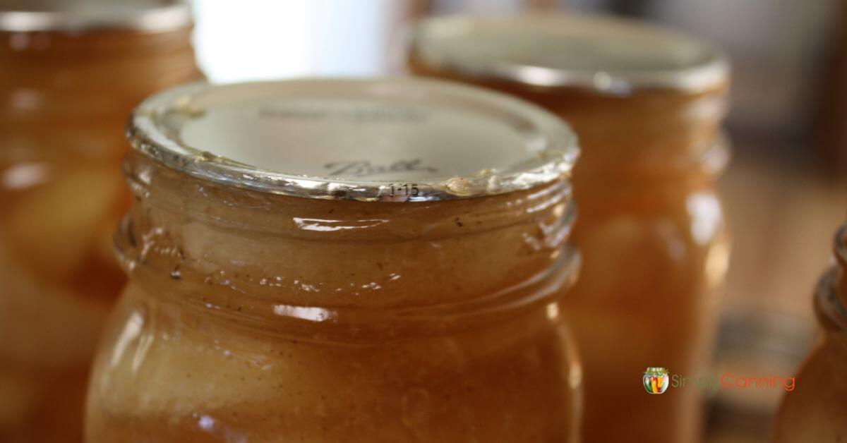 Close up of the rim of a jar of pie filling that has oozed filling through the seal.