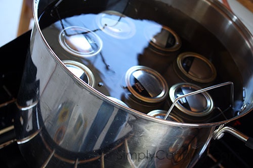 Canning jars sumerged in water in the water bath canner.