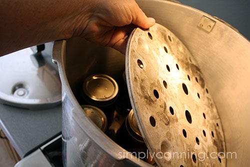 Placing a canning rack on top of a layer of jars in the pressure canner.