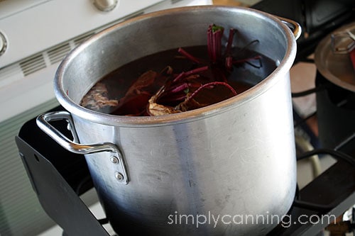 Beets cooking in a large stockpot of water.