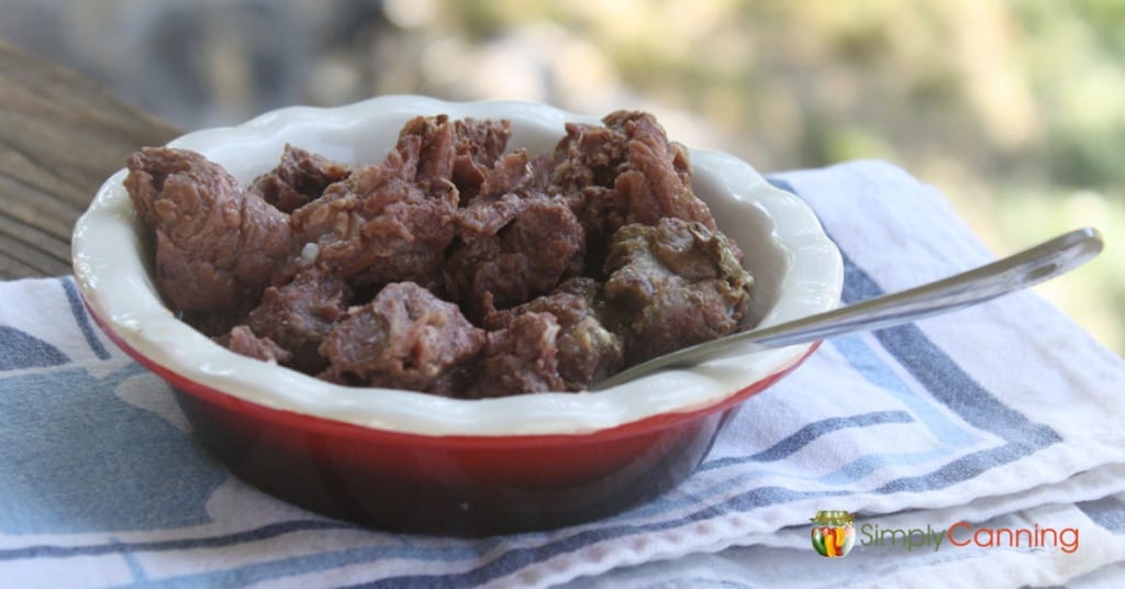 Cooked cubed venison in a glass bowel.