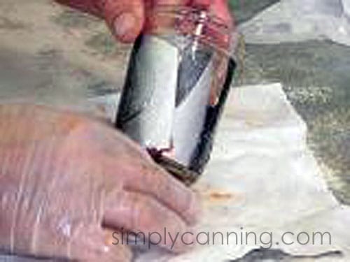 Packing fish pieces into jars with skin sides against the glass.