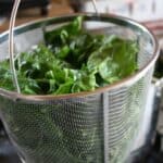 Fresh greens in a blanching basket.