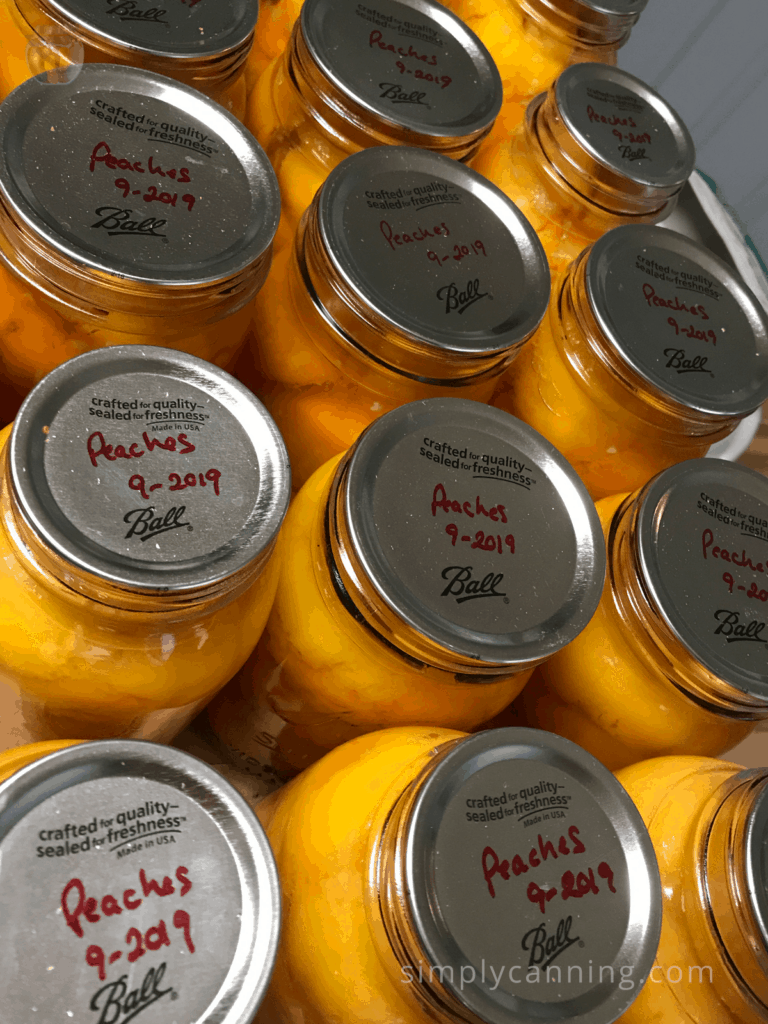 Jars of peaches labeled accordingly on the flat lids.