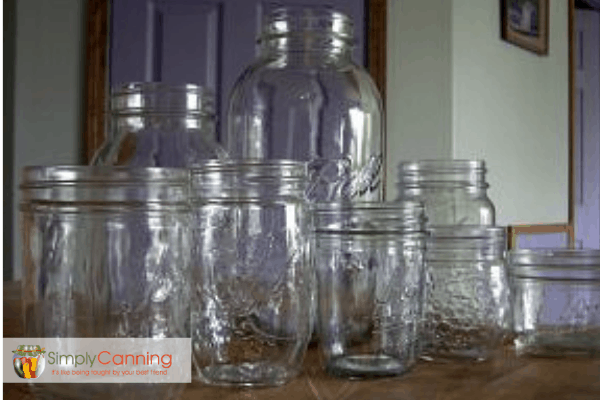 Side view of several empty canning jars of various sizes and shapes.