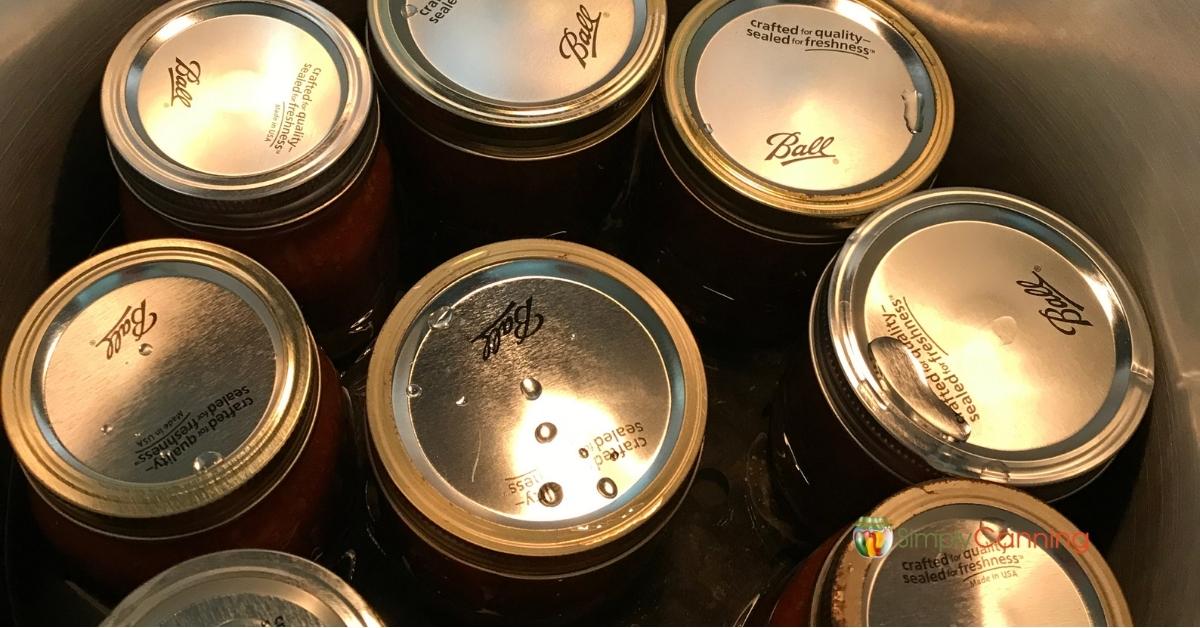 Top down view of canning jars in a pressure canner. 