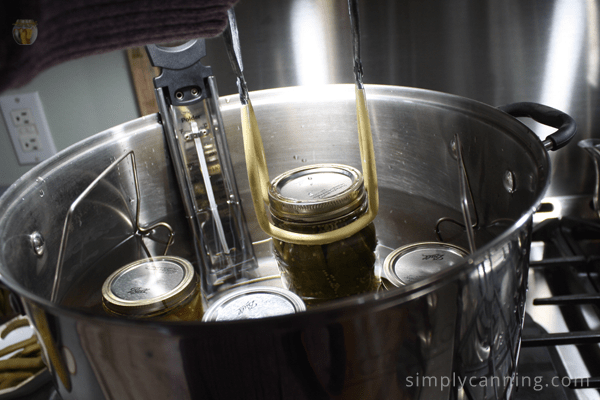 Lifting a jar into a water bath canner.